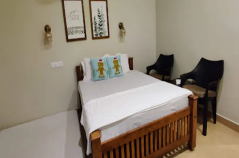 Cozy guest room bedroom featuring a wooden double bed, white linens, and modern lighting