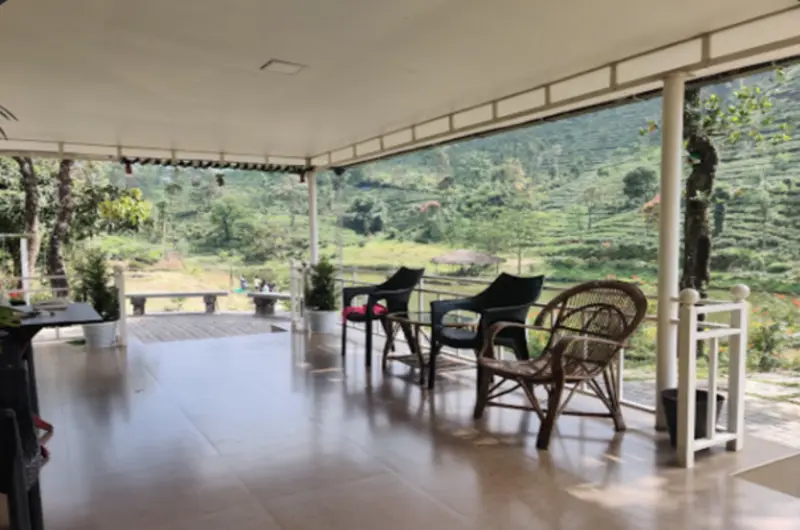 Spacious covered verandah patio with glass walls and comfortable seating overlooking gardens