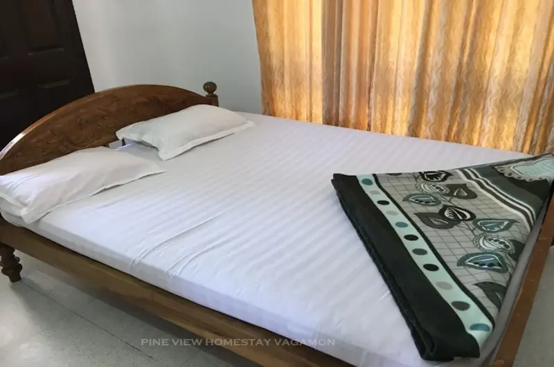 Cozy guest room featuring a double bed with colorful runner and wooden wall paneling