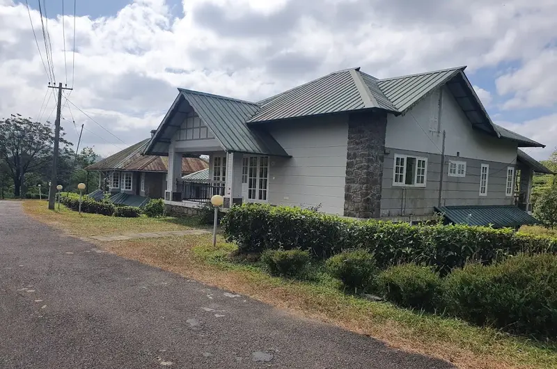 Exterior view of luxury stone villa cottage surrounded by green lawns at Orion County Vagamon