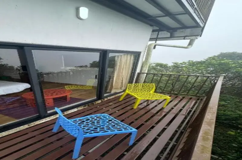 Private cottage balcony sitting area with lounge chairs overlooking valley scenery at JMount Vagamon Resort