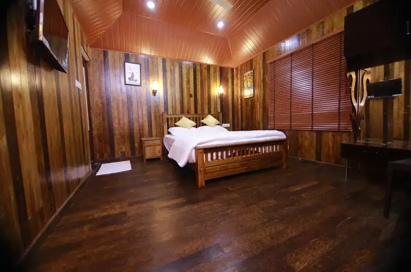 Spacious wooden attic bedroom suite with double bed and cozy timber interior wall paneling at JMount Vagamon Resort
