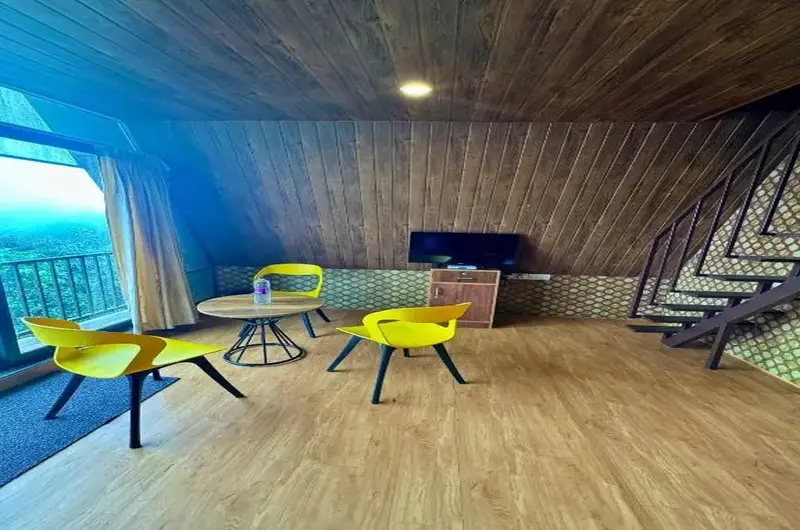 Cozy interior lounge inside an A-frame cottage with seating and scenic window view at JMount Vagamon Resort