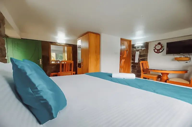 Cozy resort guest room featuring a double bed, warm ambient lighting, and bedside seating
