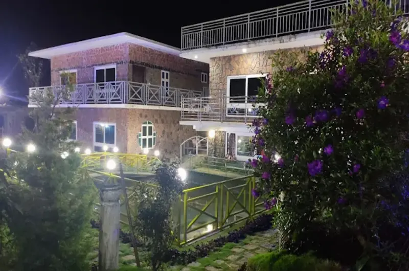 Multi-story resort building illuminated with warm exterior lights at night at Vaga Copper Castle