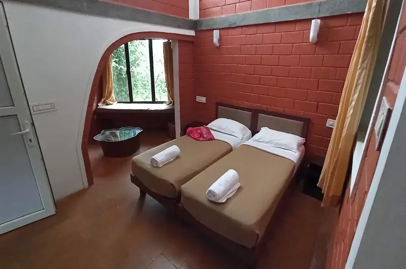 Cozy resort bedroom with exposed brick wall accent, double bed, and arched doorway