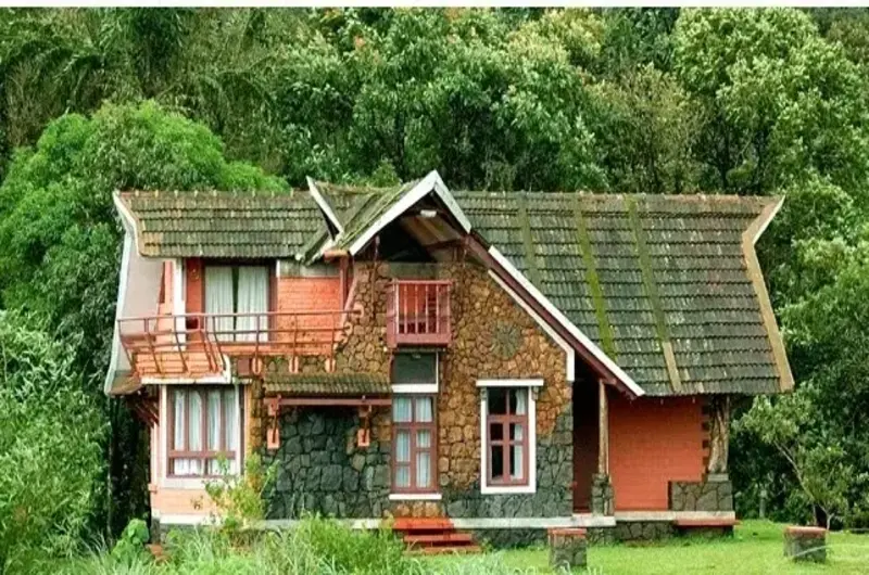 Picturesque red cottage villa nestled amidst lush green hills at Vagamon Heights