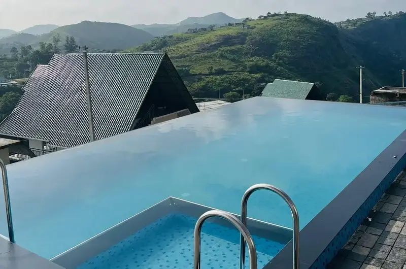 Outdoor swimming pool deck overlooking scenic mountain valleys at Vagamon Heights