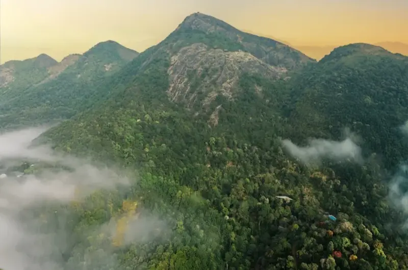 Panoramic view of misty mountain hills and lush green valleys at Ela Luxury Stay Vagamon