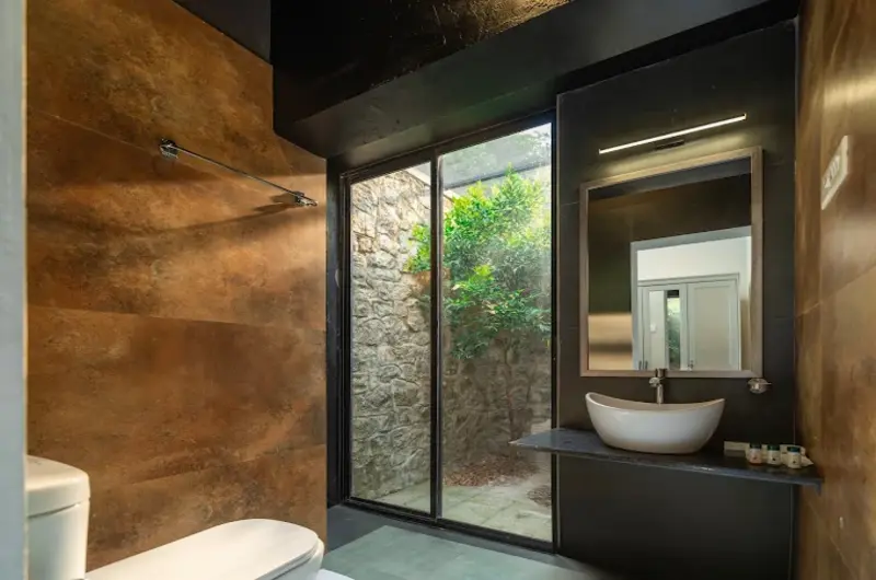 Modern guest bathroom featuring a vessel sink counter, large vanity mirror, and glass shower enclosure