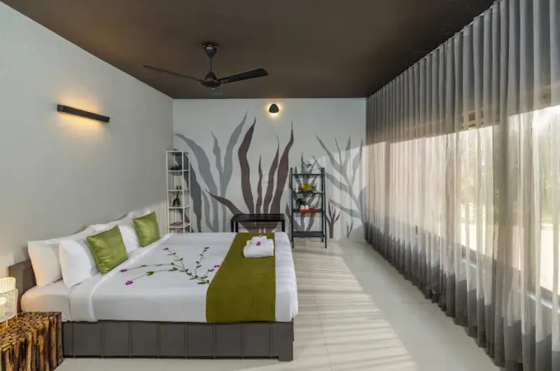 Spacious guest suite bedroom featuring king bed, ceiling fan, and large glass windows