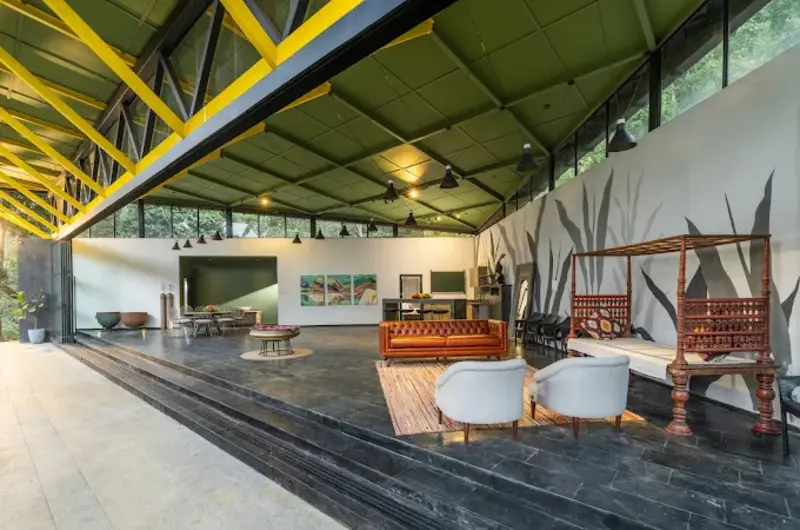 Spacious open-plan resort pavilion lounge featuring high architectural ceiling and seating
