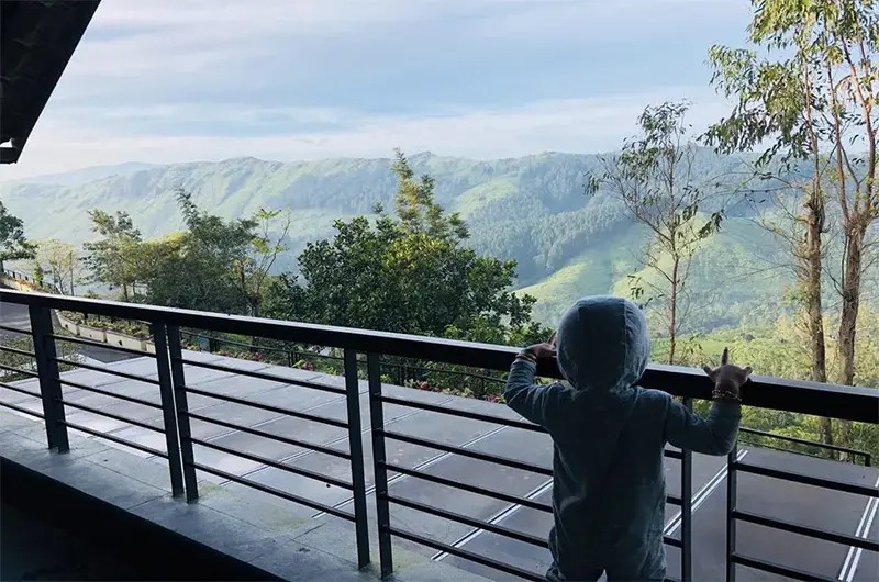 Covered balcony deck with glass railing offering scenic forest views at Beyond Pines Vagamon