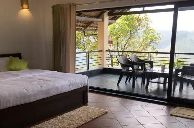 Spacious resort bedroom interior with plush double bed and floor-to-ceiling glass patio view at Beyond Pines Vagamon