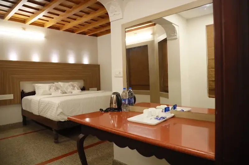Elegantly furnished wooden guest room featuring double bed and study desk at Orma Farm Resorts Vagamon