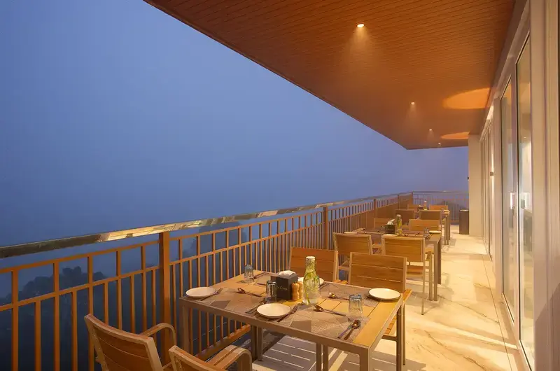 Outdoor balcony dining terrace with panoramic mountain and valley views at Le Crown Hotel Vagamon