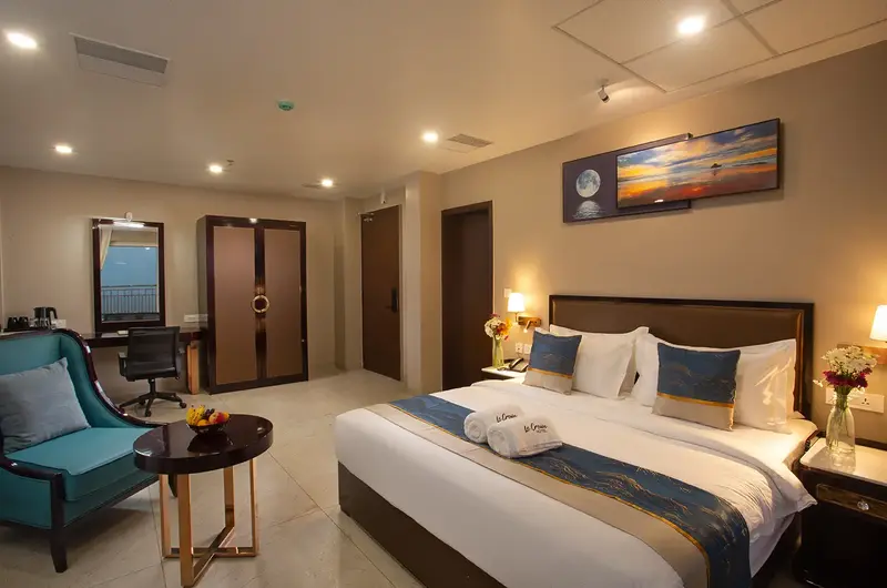 Luxury suite interior featuring double bed and cozy lounge seating at Le Crown Hotel Vagamon