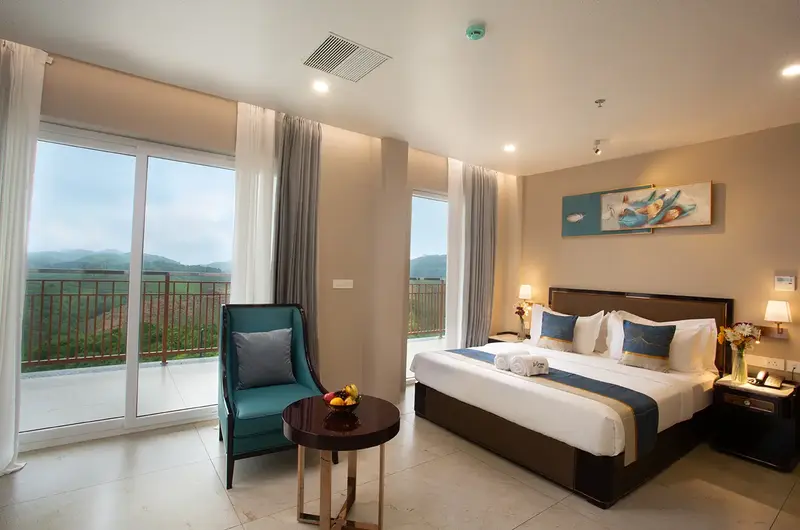 Modern guest bedroom with comfortable double bed and large scenic view window at Le Crown Hotel Vagamon