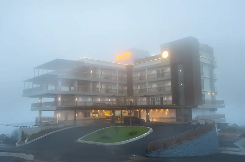 Exterior view of multi story hotel building at dusk at Le Crown Hotel Vagamon