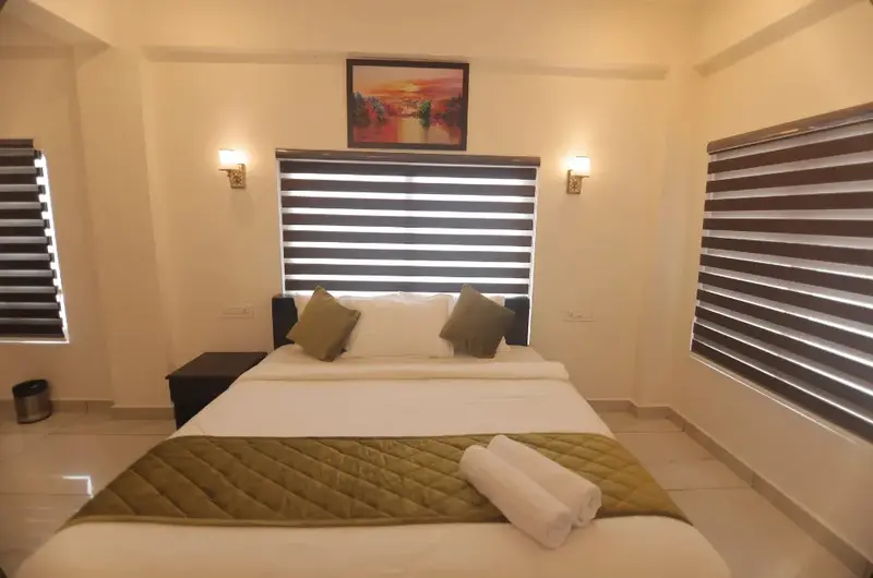 Cozy resort bedroom with comfortable double bed and warm lighting at Himasailam Resort Vagamon