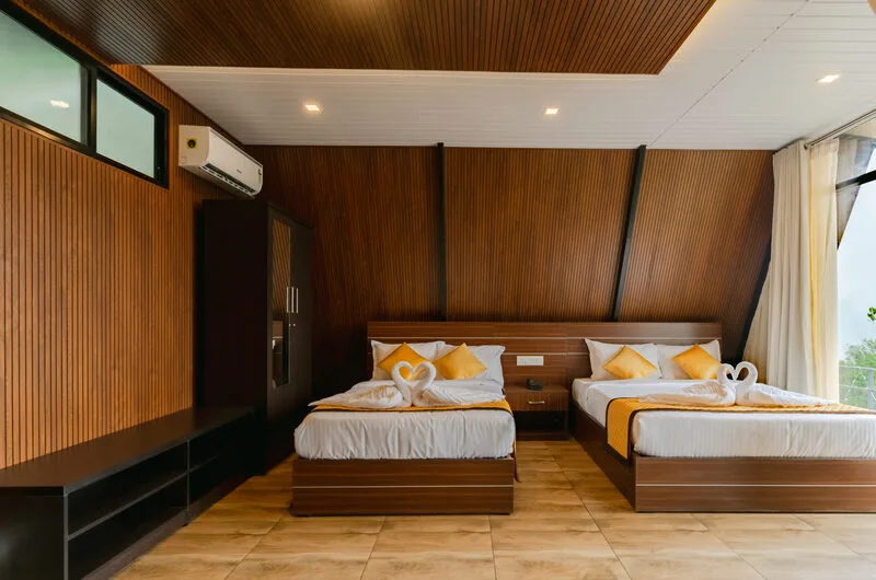 Wooden attic style suite bedroom with multiple beds at Himasailam Resort Vagamon