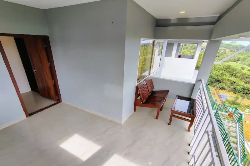 Private room balcony with seating area overlooking lush green scenery at The Autumn by Maat Hotels Vagamon