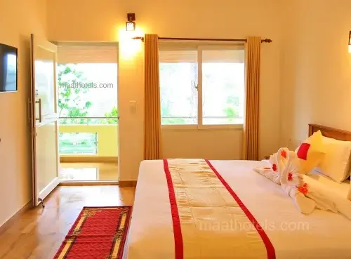 Brightly lit resort room interior with large windows and comfortable double bed at The Autumn by Maat Hotels Vagamon