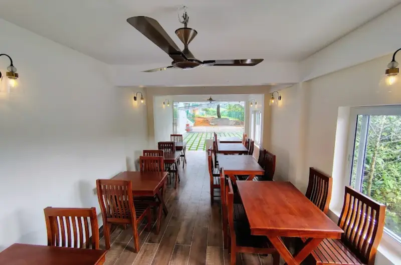 Wooden dining tables and ceiling fans in resort restaurant at The Autumn by Maat Hotels Vagamon