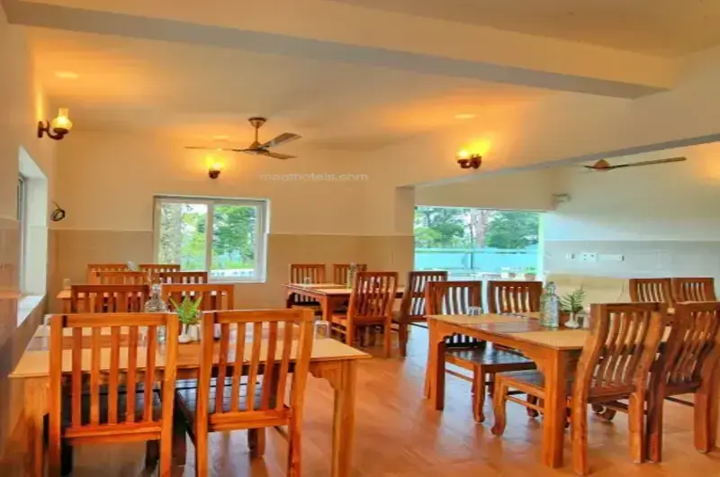 Warm wooden restaurant dining area with elegant tables at The Autumn by Maat Hotels Vagamon