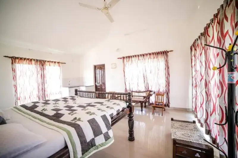 Comfortable guest room interior with double bed and patterned spread at The Nest Homestay Vagamon