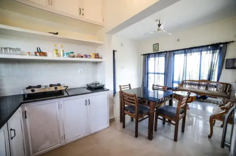 Clean interior dining hall with wooden table and seating at The Nest Homestay Vagamon