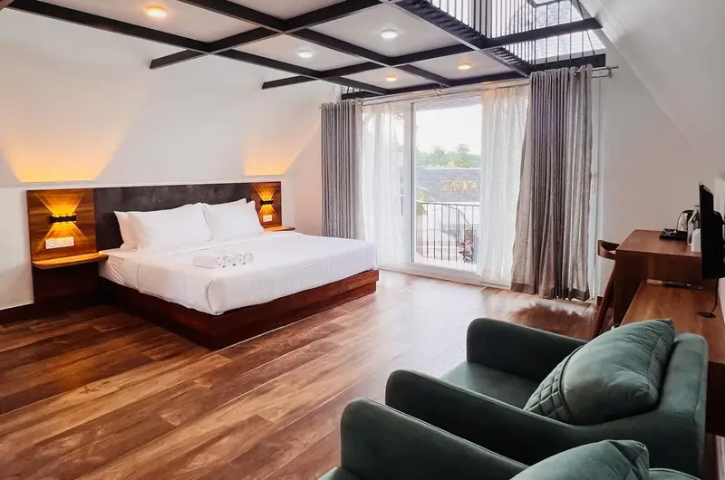 Spacious resort bedroom with seating area and scenic mountain window view at Trip Mount Vagamon