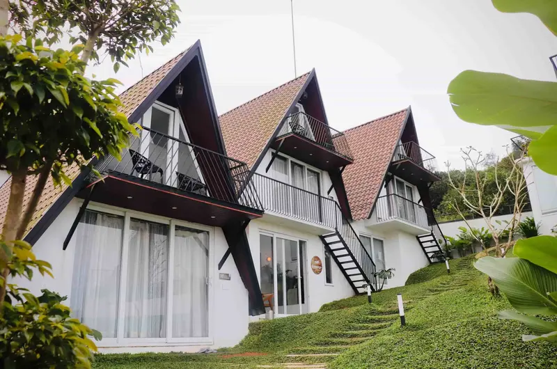Modern A-frame wooden cottages surrounded by lush greenery at Trip Mount Vagamon