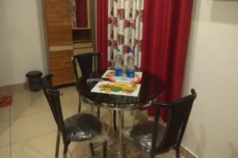 Cozy resort room seating and dining area with glass table and chairs at Thanal Farm Stay Vagamon