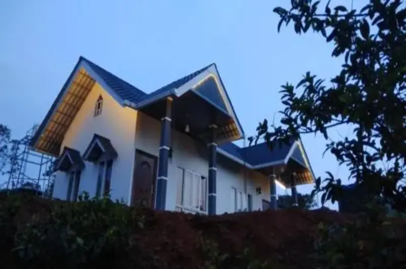 Single story farmstay cottage exterior with blue tile roof and courtyard at Thanal Farm Stay Vagamon