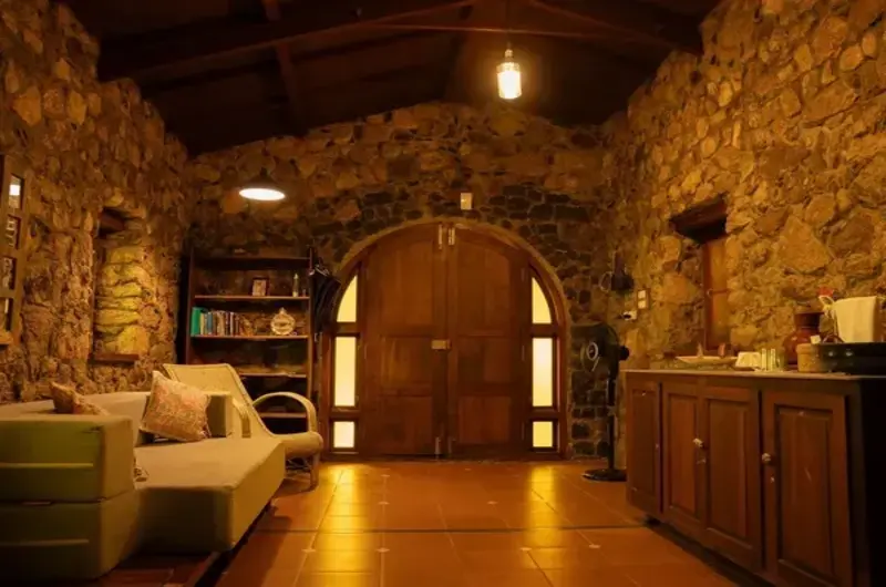 Cozy villa interior living room with exposed stone wall and warm lighting at Mountain Villa Vagamon