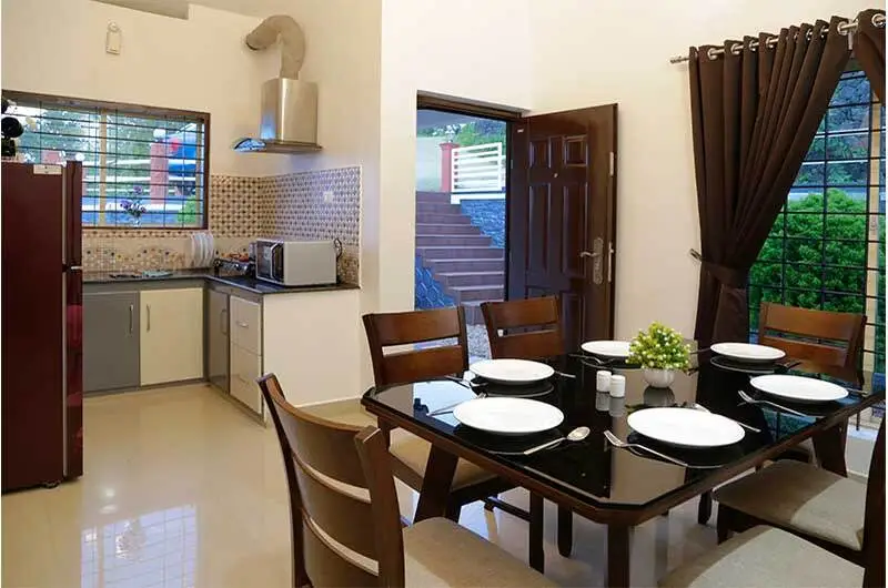 Clean dining area with wooden table and chairs inside room suite at Angel's Vagamon