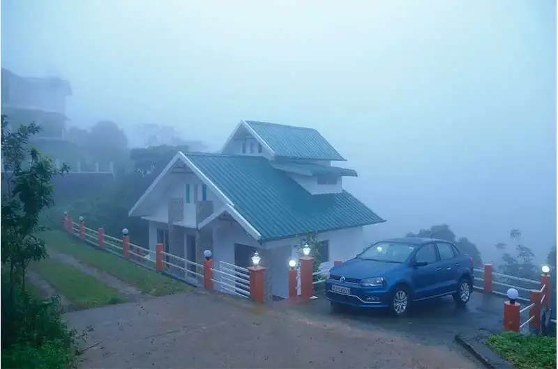 Foggy hilltop exterior view of villa building and parking area at Angel's Vagamon