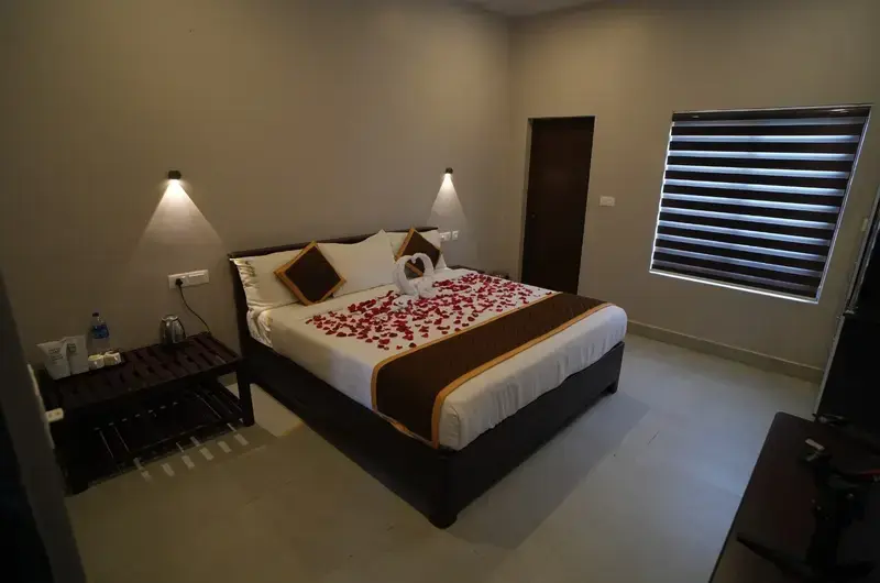 Spacious guest bedroom suite with comfortable double bed and wooden furniture at Cee Cee Grand Resort Vagamon