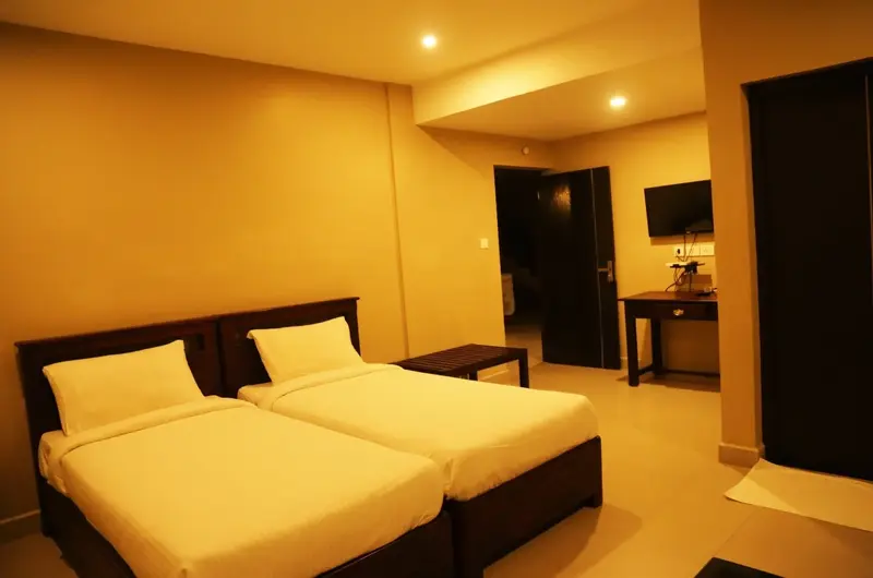 Spacious guest bedroom with two double beds and warm ambient lighting at Cee Cee Grand Resort Vagamon