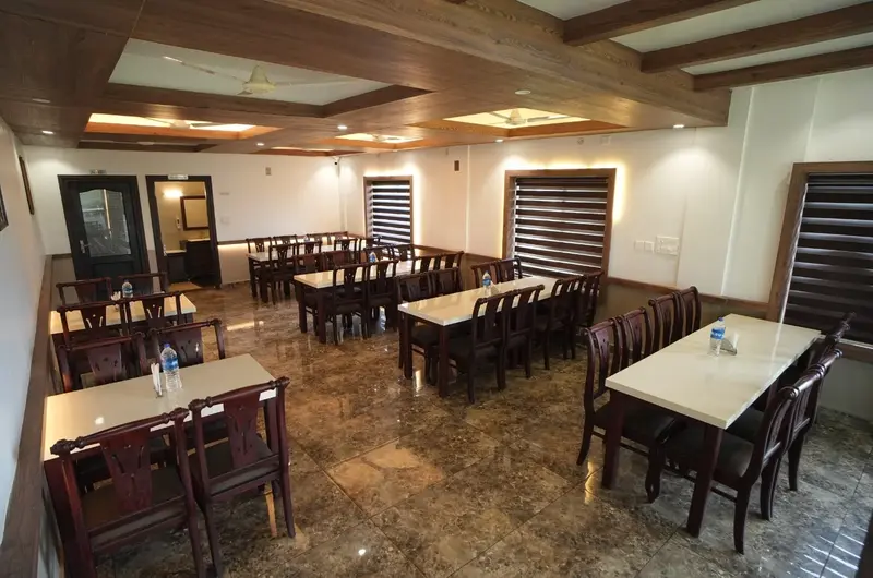 Resort restaurant dining hall with wooden tables and chairs at Cee Cee Grand Resort Vagamon