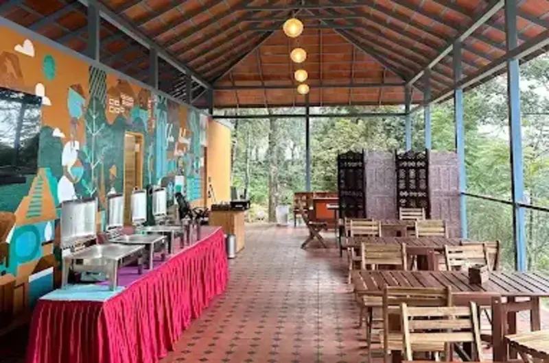 Covered outdoor dining area and event space with wooden tables at Willmount Geodesic Domes Vagamon