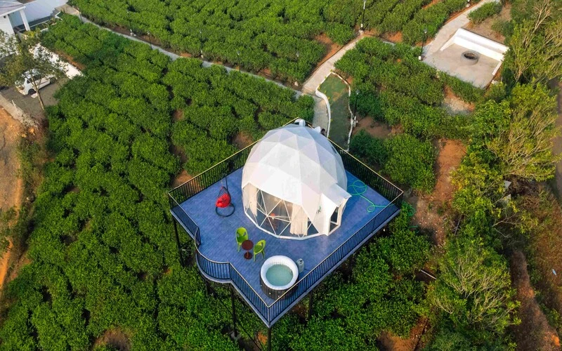 Aerial top-down view of luxury geodesic dome stay on a green hilltop at Pendora Glamps Vagamon