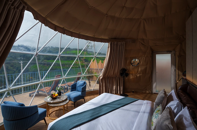 Glamping dome bedroom interior featuring panoramic window and mountain valley view at Monticle Glamps