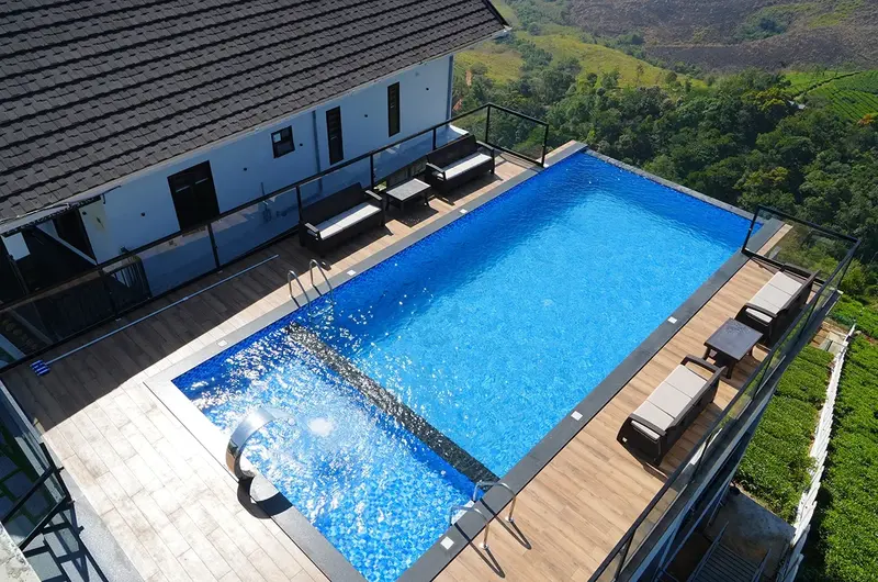 Aerial top-down view of the resort outdoor swimming pool and lounge deck in Vagamon