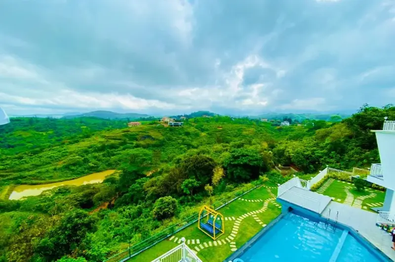 Outdoor swimming pool overlooking lush green mountain valleys at Le Collines Resort