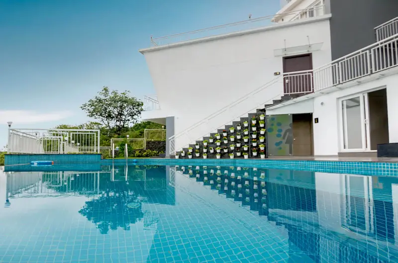 Resort outdoor swimming pool deck with modern luxury accommodation in Vagamon