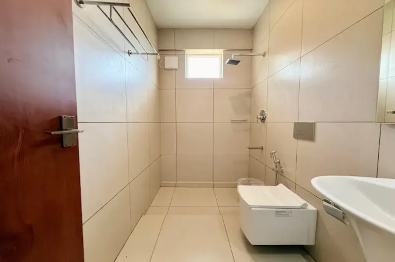 Modern tiled en-suite bathroom with glass shower enclosure and tub at Vanaheim Resort Vagamon