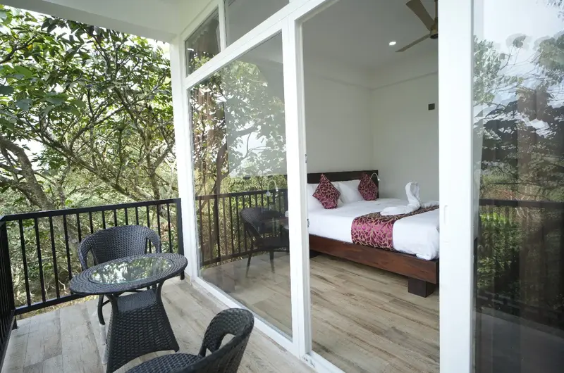 Modern resort bedroom with glass walls offering scenic forest views at Vanaheim Resort Vagamon