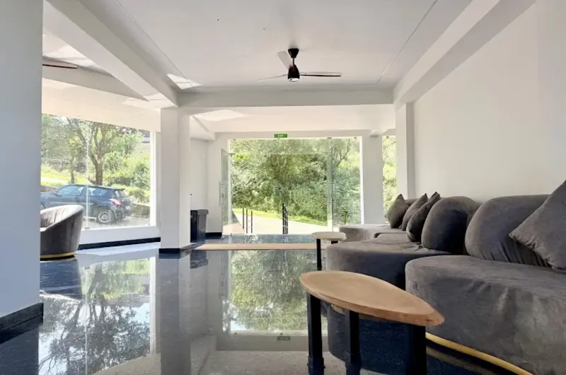 Modern luxury suite living area with large glass windows overlooking forest views at Vanaheim Resort Vagamon